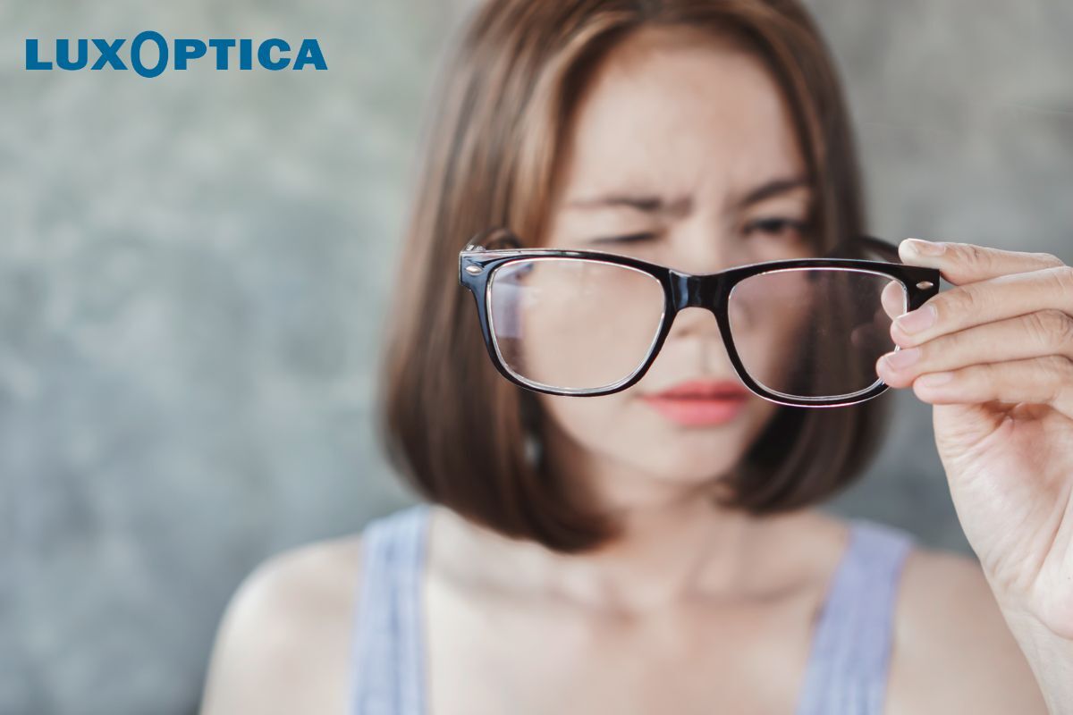 Une femme qui tient des lunettes de Luxoptica.